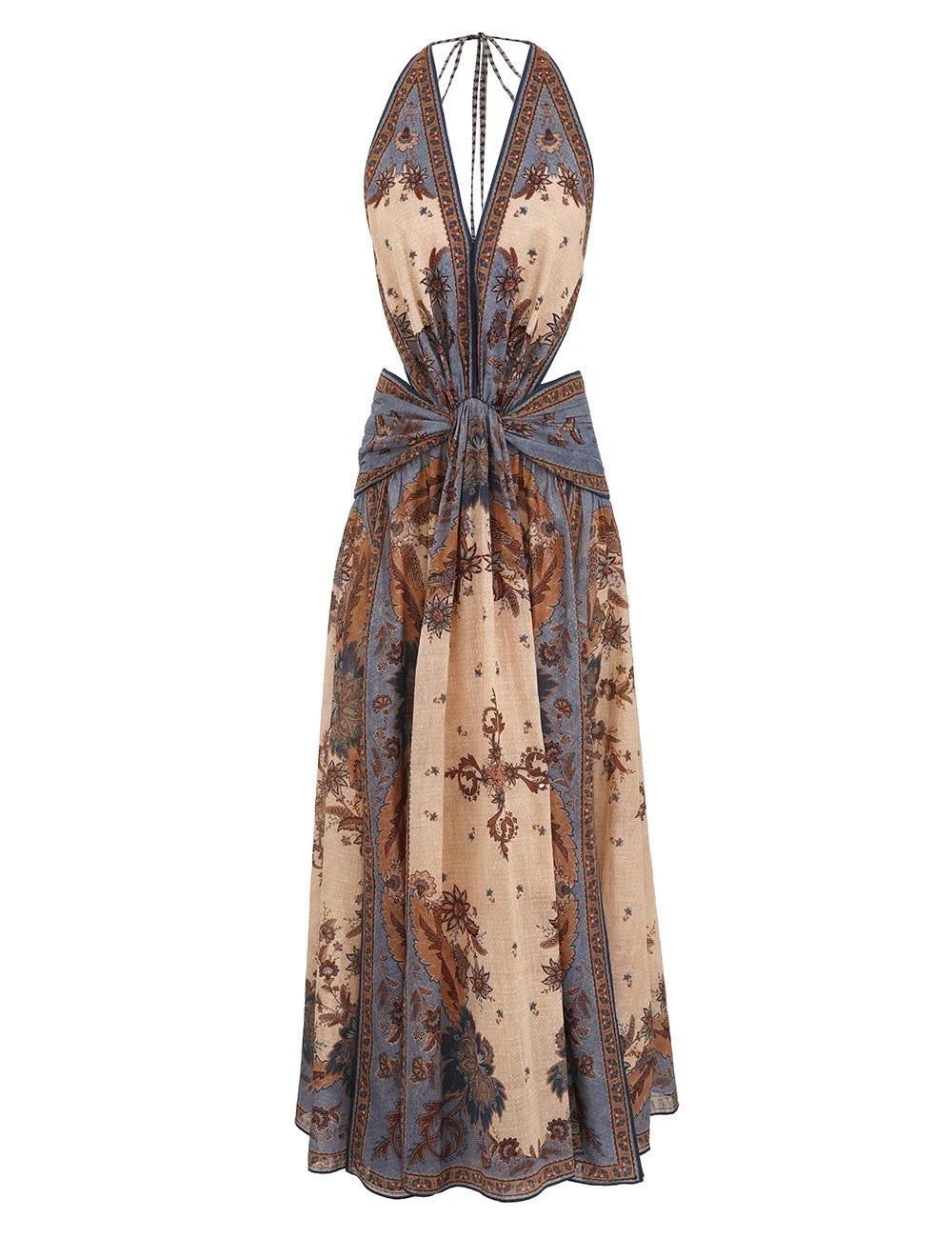 Vestido largo sin mangas, con cuello halter y nudo delantero a la altura de la cintura. Presenta un diseño fluido con abertura frontal y estampado tipo bohemio en tonos beige, marrón y azul grisáceo